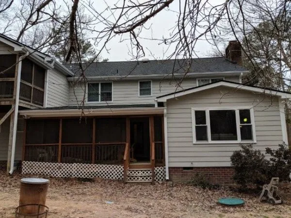Two-story gray home with a new roof and a screened porch